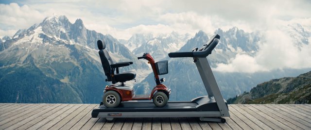 Video Reference: mobility scooter, treadmill, mountains, snowy peaks, wooden deck, outdoor, travel, landscape, equipment, wheelchair alternative, red scooter, panoramic, adventure, accessibility, fitness