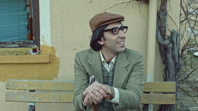 Video Reference: Glasses, Vision care, Coat, Eyewear, Temple, Dress shirt, Beard, Smile, Street fashion, Cap