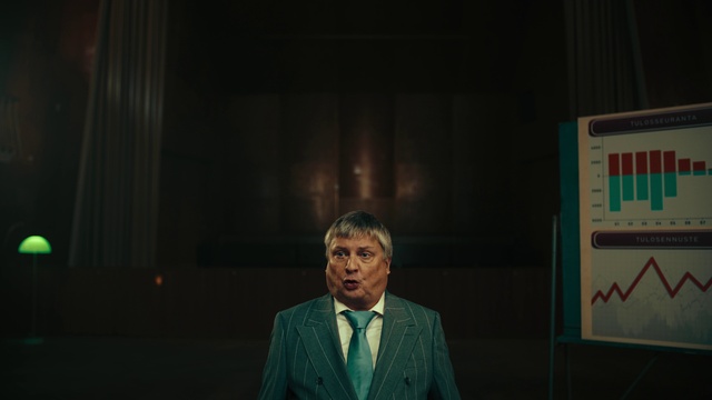 Video Reference: Tie, Blazer, Spokesperson, Suit, Event, Formal wear, Official, Curtain, Speech, Speaker