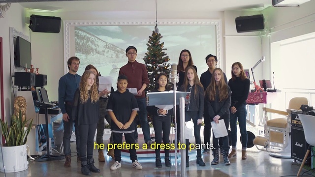 Video Reference: Footwear, Trousers, Christmas tree, Chair, Standing, Interior design, Social group, Entertainment, Leisure, Suit