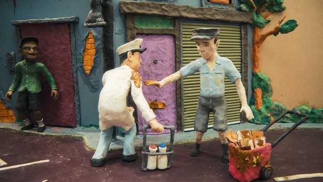 Video Reference: stop-motion, clay, animation, street scene, figures, cart, bottles, packages, doors, building facade, tree, urban, model, handmade, miniature, outdoor