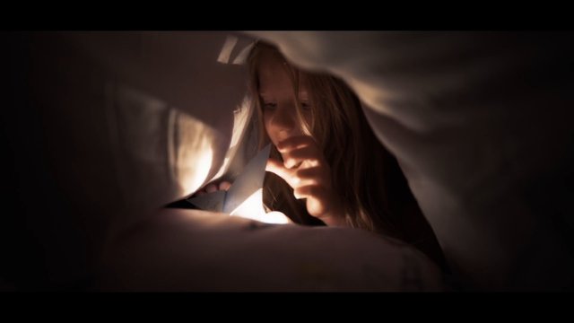 Video Reference: child, girl, close up, indoor, low light, warm light, play, tent, blanket fort, candid, childhood, intimate, soft focus