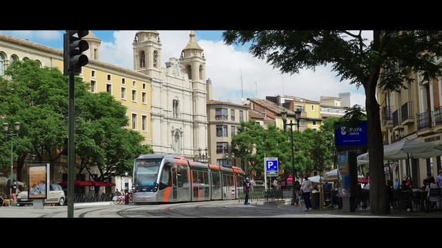 Video Reference: Train, Sky, Building, Tree, Vehicle, Window, Architecture, Electricity, Travel, Thoroughfare