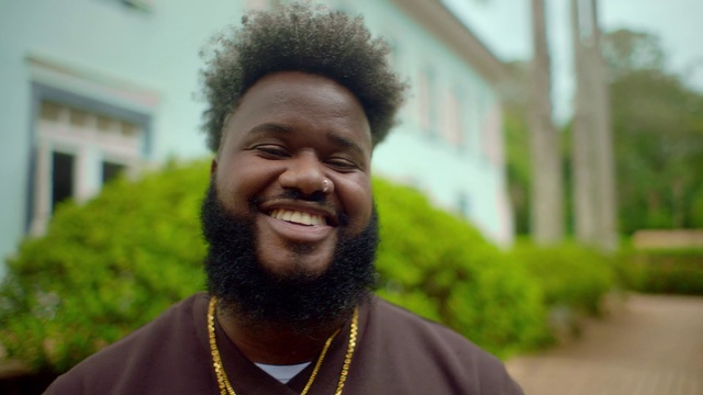 Video Reference: Hair, Forehead, Face, Smile, Head, Chin, Hairstyle, Facial expression, Beard, Leaf