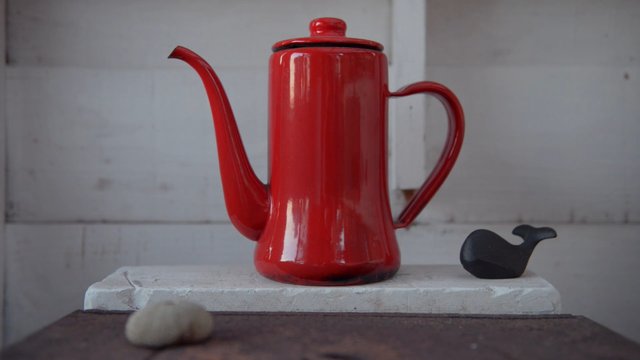 Video Reference: coffee pot, red, metal, still life, kitchenware, whale figurine, minimalist, indoor, table, plain background, ceramic, object