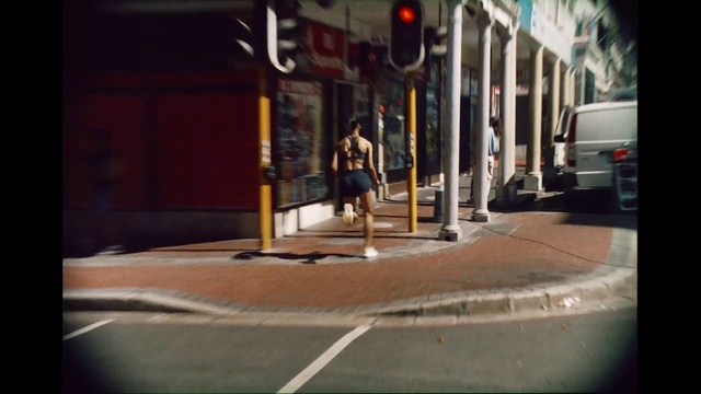 Video Reference: Automotive lighting, Asphalt, Road surface, Tints and shades, Sidewalk, Road, Car, City, Font, Pedestrian