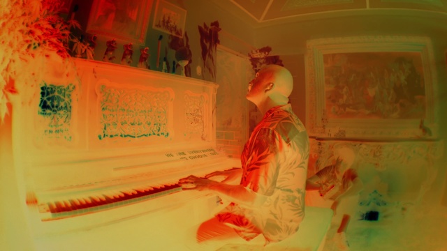 Video Reference: Orange, Art, Musical instrument, Event, Font, Visual arts, Room, Paint, Office supplies, Hat