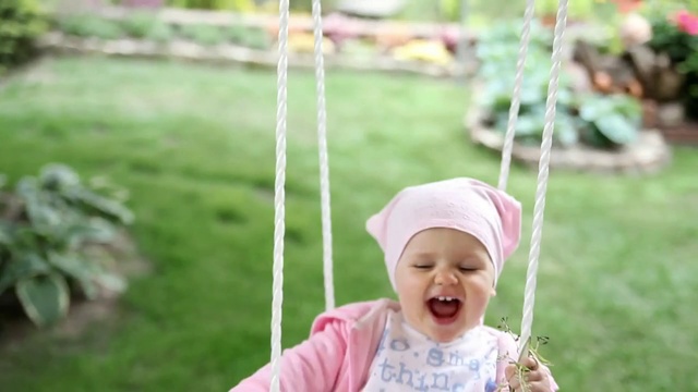 Video Reference: Swing, Child, Outdoor play equipment, Toddler, Baby, Play, Smile, Person, Grass, Outdoor, Little, Holding, Object, Sitting, Small, Table, Girl, Smiling, Young, Field, Park, Riding, Standing, Green, White, Plate, Wearing, Cake, Umbrella, Hat, Pink, Playing, Grassy, Bat, Blue, Red, Pizza, Playground, Human face, Clothing, Outdoor object, Boy