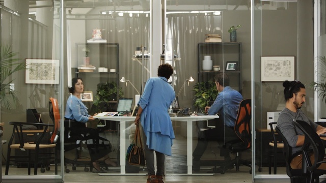 Video Reference: Building, Room, Interior design, Job, Event, Office, Window, Furniture, White-collar worker, Door, Person, Indoor, Table, People, Chair, Man, Food, Group, Woman, Standing, Sitting, Kitchen, Computer, Talking, Desk, Young, Bench, Walking, Restaurant, Living, Luggage, Display, White, Floor, Clothing, Office building, Design