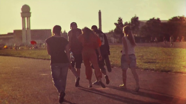Video Reference: Atmospheric phenomenon, Morning, Fun, Sunlight, Evening, Team, Person, Outdoor, Grass, Walking, Man, Standing, Field, Holding, Woman, Carrying, Playing, Street, Wearing, Cross, Riding, Game, Group, Player, Young, People, Skiing, Ball, City, Elephant, Soccer, Red, Sunset, Track, Clothing, Footwear, Sky, Tree