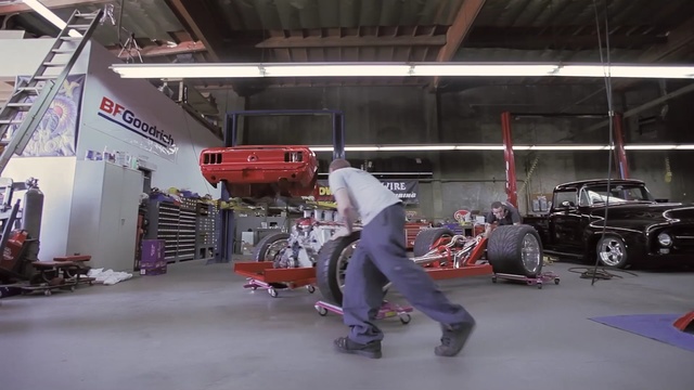 Video Reference: car, automobile repair shop, vehicle, race track, race, sport venue, machine