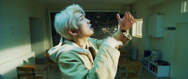 Video Reference: Room, Photography, Gesture, Jaw, Person, Indoor, Holding, Standing, Woman, Young, Looking, Front, Green, Wearing, Man, Hand, Girl, Table, Hair, Shirt, Boy, Little, White, Kitchen, Remote, Living, Mouth, Video, Playing, Blue, Wall, Human face, Clothing