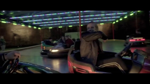 Video Reference: Amusement ride, Automotive exterior, Mode of transport, Vehicle, Pc game, Amusement park, Fun, Bumper, Recreation, Automotive design, Person, Indoor, Table, Window, Man, Computer, Laptop, Sitting, Desk, Room, Woman, Young, People, Holding, Standing, Phone, Living, Playing, Car, Doing, Riding, Land vehicle, Night, Wheel, Bumper car, Golfcart