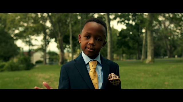 Video Reference: Coat, Flash photography, Tree, Dress shirt, Happy, Gesture, Tie, Plant, Suit, Grass
