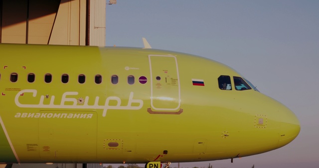 Video Reference: Aviation, Air travel, Airplane, Airline, Airliner, Aerospace engineering, Aircraft, Vehicle, Yellow, Flap, Plane, Outdoor, Airport, Large, Transport, Runway, Sitting, Parked, Jet, Passenger, Commercial, Tarmac, Air, Green, Truck, Blue, Sky