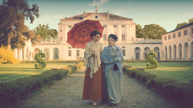 Video Reference: Architecture, Photography, Building, Art, History, Palace, Tourism, Classic, House, Tourist attraction, Person, Grass, Outdoor, Road, Man, Front, Walking, Standing, Holding, Yellow, Young, Path, Boy, Carrying, Street, Woman, Red, Park, Field, Green, Umbrella, Wearing, Old, Large, Dirt, Suitcase, Sign, Track, Riding, Sky, Clothing