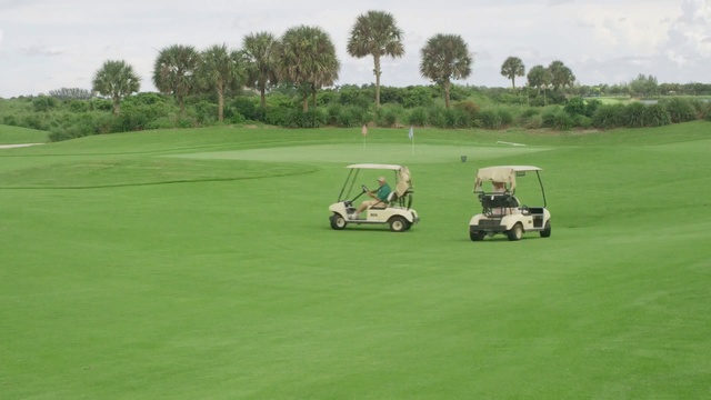 Video Reference: golf equipment, motor vehicle, sports equipment, equipment, wheeled vehicle, golf, course, grass, sport, golfing, vehicle, recreation, ball, fairway, club, game, hole, golfer, leisure