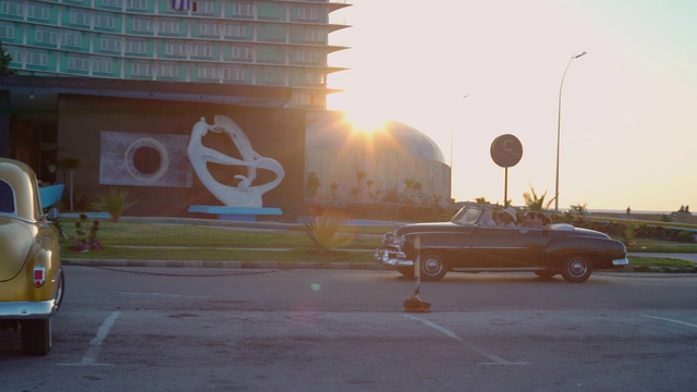 Video Reference: Vehicle, Mode of transport, Car, Art, Luxury vehicle, Graffiti, Mural, Street art, Mid-size car, Asphalt, Outdoor, Road, Building, Street, Sitting, Orange, Parked, Light, Truck, Side, Large, Traffic, Lot, Parking, Driving, Yellow, Green, Fire, City, Runway, Riding, Stop, Man, White, Standing, Tarmac, Plane, Bus, People, Sky, Land vehicle, Wheel, Day