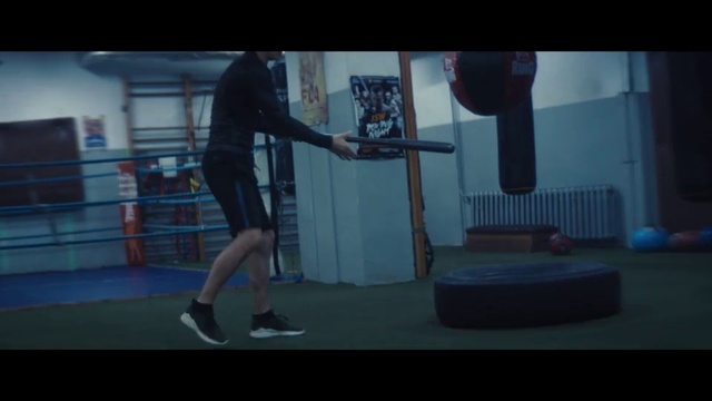 Video Reference: Human leg, Arm, Sports training, Physical fitness, Leg, Room, Exercise equipment, Screenshot, Muscle, Performance, Indoor, Man, Holding, Woman, Racket, Ball, Standing, Court, Playing, Player, Young, Blue, Jumping, Walking, Swinging, Air, Board, Suitcase, Game, White, Doing, Dance, Footwear, Clothing