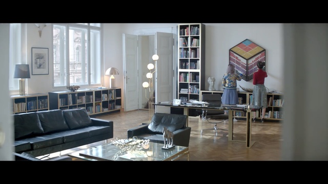 Video Reference: Furniture, Living room, Room, Property, Interior design, Building, Table, Floor, Couch, Chair, Person