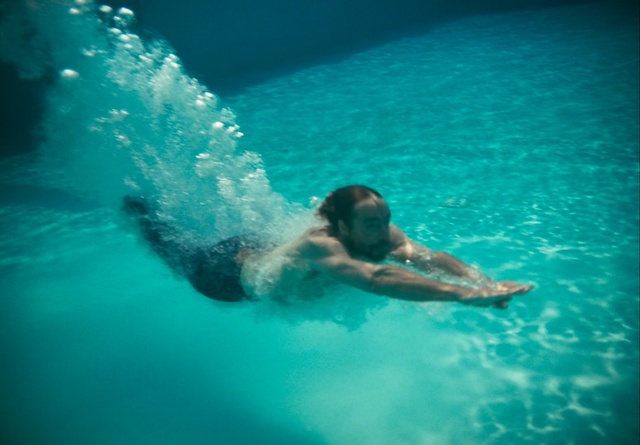 Video Reference: Water, Blue, Green, Aqua, Wave, Turquoise, Leisure, Fun, Recreation, Sky, Sport, Swimming, Riding, Pool, Ocean, Man, Board, Large, Body, Game, Surfing, Young, Bear, Frisbee, Purple, Clear, Laying, Flying, Water sport, Swimming pool, Person