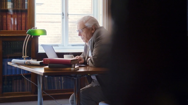 Video Reference: Sitting, Desk, Furniture, Table, Room, Glasses, Interior design, Chair, Conversation, Reading