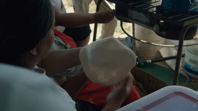 Video Reference: , Person, Sitting, Table, Man, Food, Woman, Front, Eating, Young, People, Shirt, Cake, Room, Standing, Group, Pizza, Red, Computer, Holding, Kitchen, White, Clothing, Meal