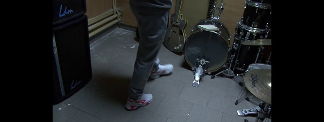 Video Reference: Drum, Musical instrument, Drumhead, Drums, Bass drum, Idiophone, Tom-tom drum, Percussion, Snare drum, Cymbal, Indoor, Person, Sitting, Small, Table, Holding, Woman, Shoes, Standing, Young, Man, Black, Motorcycle, Room, Girl, Wearing, White, Kitchen, Dog, Luggage, Sink, Floor, Clothing, Concert, Guitar, Footwear, Jeans