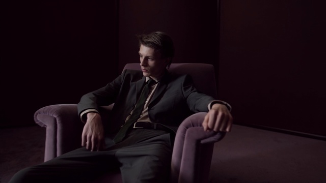 Video Reference: Sitting, Gentleman, Male, Photography, Furniture, Darkness, Portrait, Facial hair, Suit, Person
