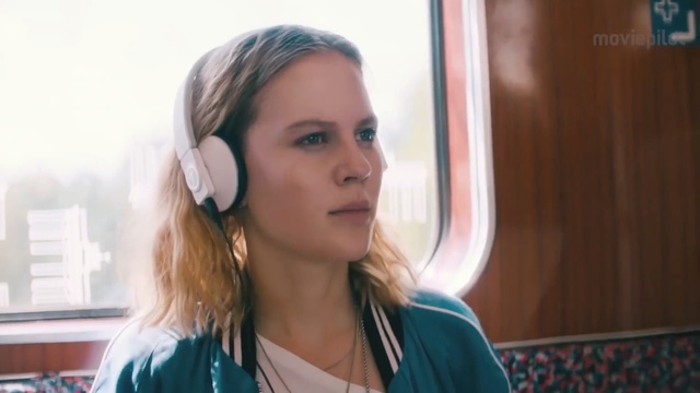 Video Reference: Hair, Face, Audio equipment, Ear, Hairstyle, Head, Blond, Eyebrow, Chin, Cheek, Person