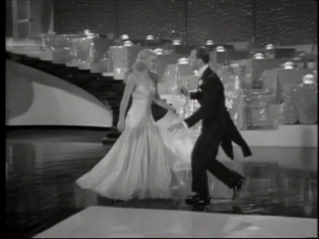 Video Reference: Wedding dress, Bridal clothing, Bride, Coat, Flash photography, Dress, Gesture, Black-and-white, Happy, Gown