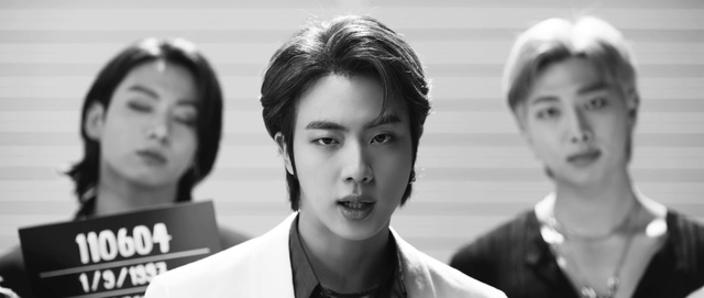 Video Reference: Forehead, Eyebrow, Facial expression, Black, Jaw, Eyelash, Black-and-white, Street fashion, Coat, Style