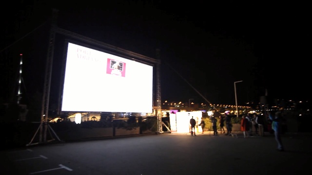 Video Reference: stage, night, light, darkness, sky, display device, city, advertising