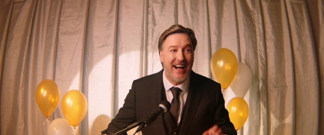Video Reference: Microphone, Smile, Public address system, Organ, Tie, Balloon, Lighting, Suit, Social group, Happy