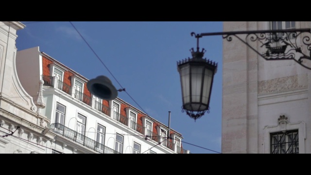 Video Reference: town, landmark, sky, light fixture, building, architecture, facade, lighting, street light, city, Person
