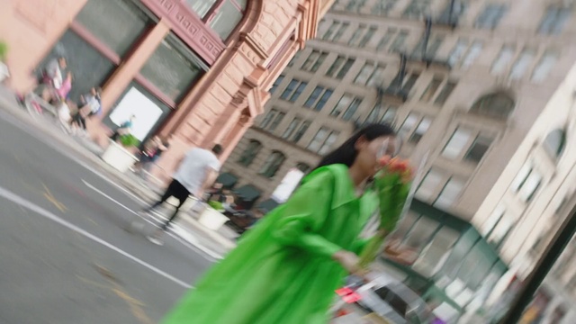 Video Reference: Green, Snapshot, Street, Pedestrian, Street fashion, City, Building, Outdoor, Table, Sitting, Man, Tall, Food, Woman, Large, Glass, Holding, Standing, Red, Young, Vase, Yellow, Riding, White, People, Umbrella, Plate, Pizza, Person, Clothing