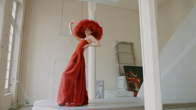 Video Reference: Red, Red hair, Dress, Wig, Room, Shoulder, Outerwear, Gown, Window, Textile