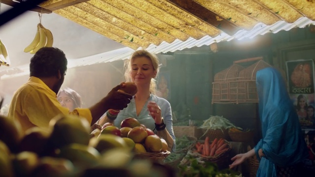 Video Reference: Adaptation, Person, Indoor, Table, Food, Standing, Man, Display, Cake, Woman, Counter, People, Front, Store, Sitting, Group, Fruit, Filled, Large, Bunch, Room, Cutting, Plate, Holding, Produce, White, Kitchen, Vegetable, Human face