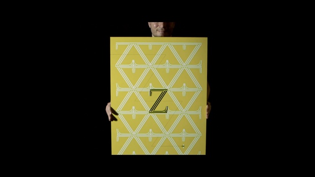 Video Reference: yellow, text, font, symmetry, pattern, square, rectangle, angle, gold, computer wallpaper, Person