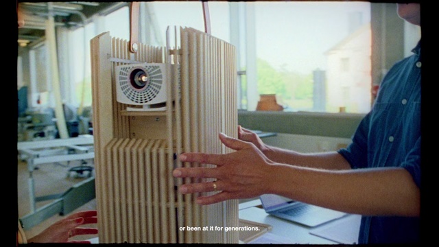 Video Reference: Wood, Person, Indoor, Window, Table, Man, Sitting, Food, Front, Laptop, Computer, Looking, Woman, Using, Plate, Kitchen, Holding, Young, Standing, Pizza, Sandwich, White, Room, People, Text, Clock