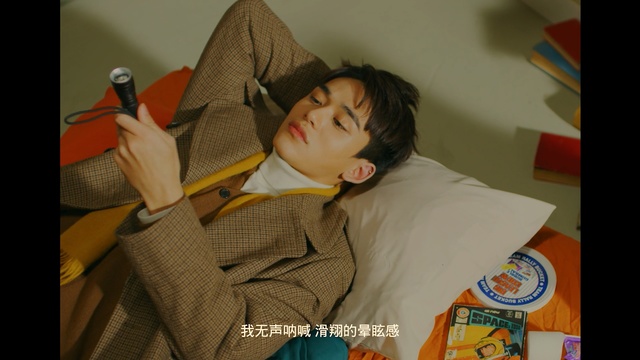 Video Reference: man, asian, lie, bed, flashlight, room, jacket, suit , Person