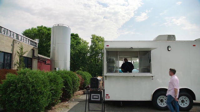 Video Reference: Vehicle, Truck, Car, Building, Plant, House, Trailer, Person, Outdoor, Road, Man, Front, Small, Street, Standing, Riding, People, White, Parked, City, Large, Red, Woman, Holding, Bus, Board, Sky, Tree, Waste container