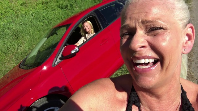 Video Reference: Facial expression, Vehicle, Car, Smile, Blond, Vehicle door, Photography, Compact car, Selfie, Laugh, Person, Grass, Outdoor, Man, Smiling, Wearing, Red, Looking, Front, Camera, Posing, Glasses, Black, Head, Face, Dog, Holding, Driving, Truck, Standing, Hot, Large, Close, Woman, Talking, Hat, White, Riding, Phone, Bus, Field, Hotdog, Human face, Land vehicle, Clothing