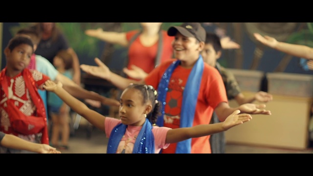 Video Reference: Youth, Event, Fun, Performance, Tradition, Dance, Happy, Choreography, Dancer, Person, Sport, Woman, Game, Standing, Playing, Man, Player, Ball, Racket, Female, Young, Swinging, Girl, Holding, Crowd, Doing, People, Court, Human face, Boy, Clothing, Text, Smile, Toddler, Screenshot, Child