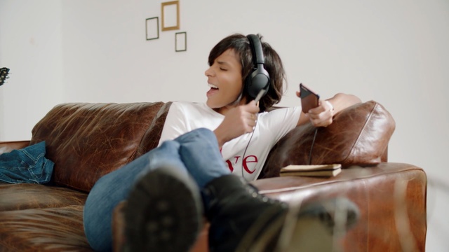 Video Reference: Furniture, Room, Leg, Audio equipment, Textile, Electronic device, Sitting, Ear, Comfort, Person