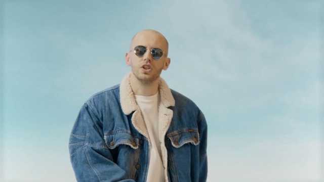 Video Reference: Eyewear, Denim, Jeans, Sunglasses, Cool, Glasses, Human, Gentleman, Textile, Photography, Person, Outdoor, Man, Standing, Wearing, Holding, Water, Woman, Blue, Shirt, Young, Boat, Sign, Street, Field, Phone, Sky, Clothing, Human face, Jacket, Goggles, Sleeve