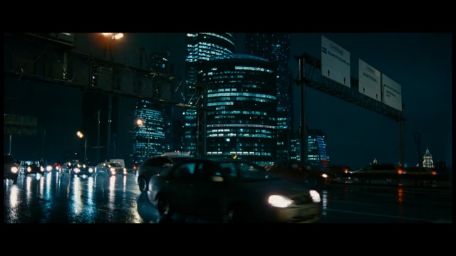 Video Reference: Metropolitan area, Metropolis, Cityscape, City, Night, Urban area, Downtown, Human settlement, Darkness, Skyline, Person, Outdoor, Building, Street, Traffic, Light, Large, View, Sitting, Water, Driving, Busy, Standing, Rain, White, Road, Sign, Group, Bus, Tall, Parked, Skyscraper, Car, Vehicle, Text, Sky, Land vehicle