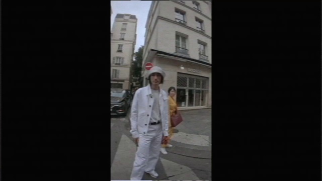Video Reference: White, Photograph, Standing, Uniform, Snapshot, Suit, Human, Outerwear, Infrastructure, Formal wear