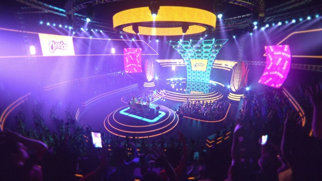 Video Reference: Entertainment, Visual effect lighting, Light, Nightclub, Electronics, Lighting, Stage, Performance, Purple, Music venue, Indoor, Scene, Table, Monitor, Computer, Screen, Front, Video, Standing, Laptop, Room, Man, Display, Sitting, Lit, Keyboard, Game, Television, Night, Holding, Phone, Playing, Cake, Red, Remote, White, Group, Text, Concert