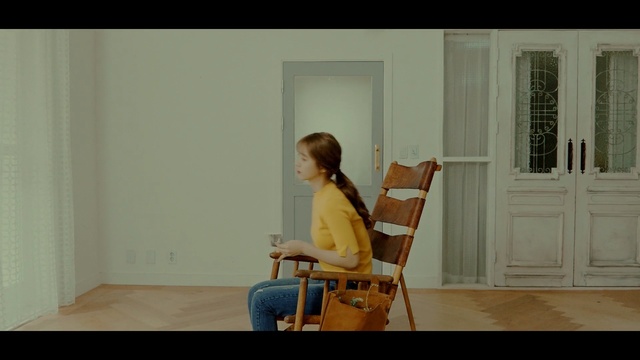 Video Reference: sitting, furniture, room, chair, girl, table, wood, floor, flooring, window, Person